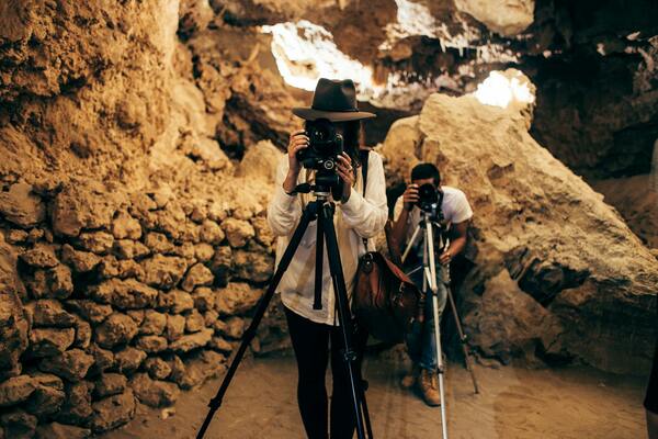 Two reporters behind the cameras in a cave. Photo by Rachel Claire/Pexel