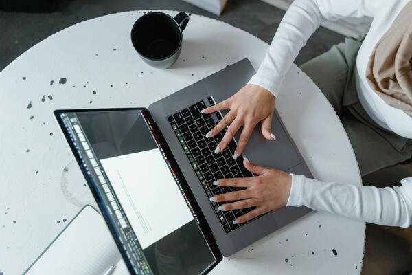 Women sitting at a table, using laptop and drinking coffee