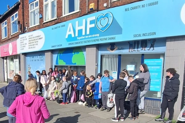Group of young people outside An Hour for Others charity shop in Liverpool