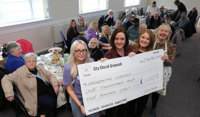 Photo of cheque being presented at afternoon tea