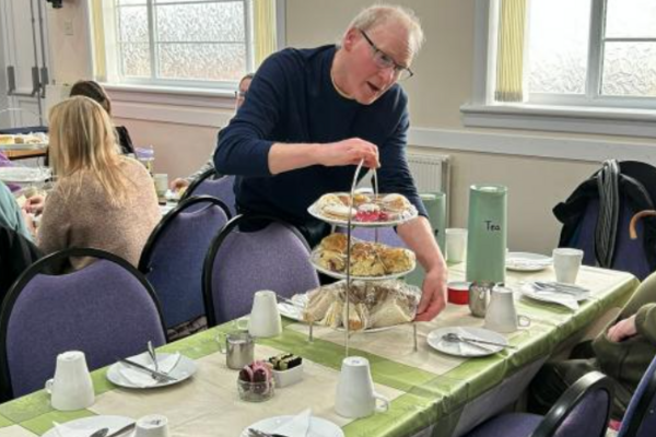 Man serving a stand of afternoon tea