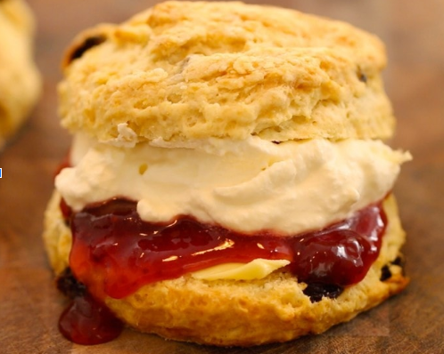 Photo of scone with cream and jam oozing out