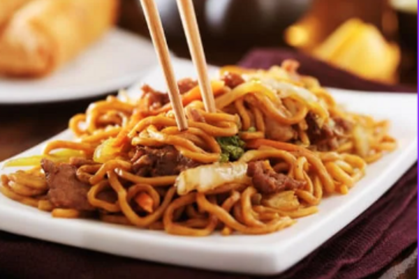 plate with chinese noodles and chopsticks