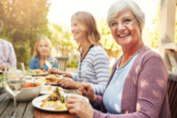 people round a table enjoying food and wine