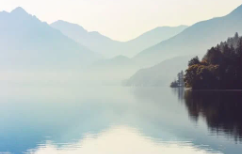 misty view of loch and reflection of mountains