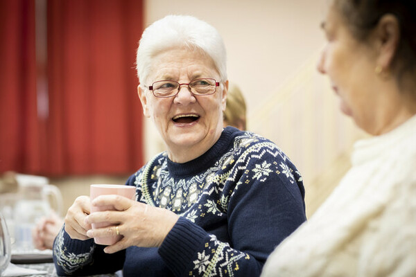 woman in blue jumper having a coffee