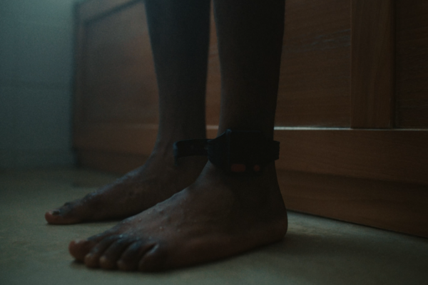 image of a man bare foot with and ankle tag on his left side 