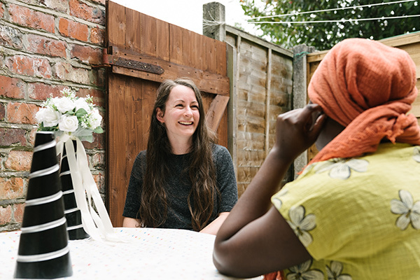 Two women talking and smiling in a garden