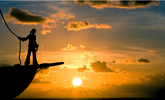 photo of a ships silhouette with captain stood at the bow and the sun setting