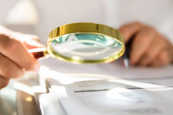 A magnifying glass being held over a sheet of paper