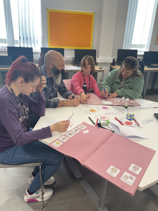 A group of beneficiaries and volunteers doing art together