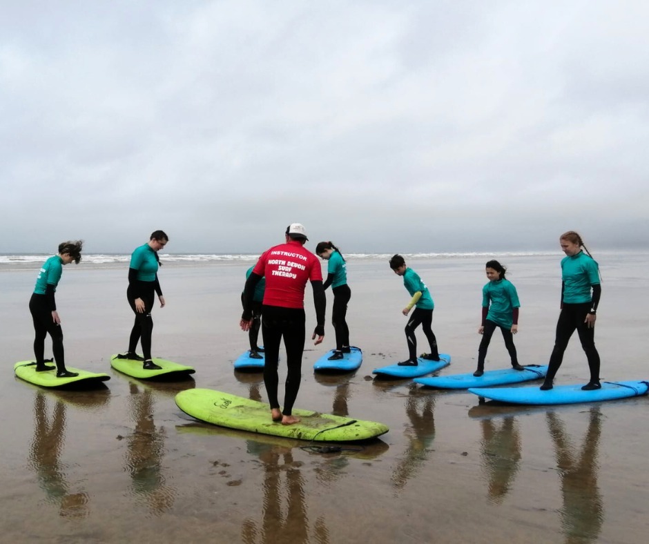 A group of people on surf boards at a surf school