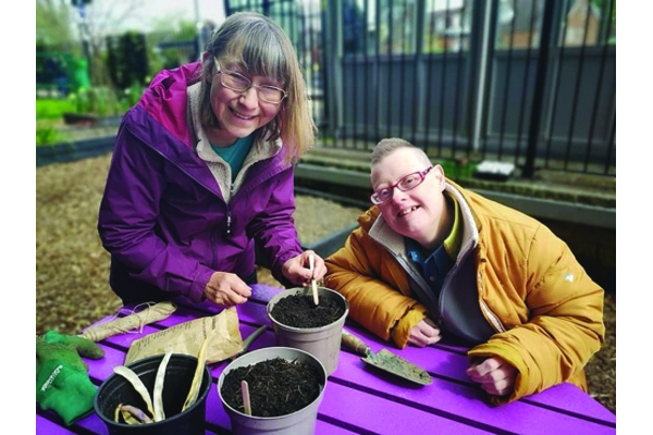 A volunteer an charity client planting seeds