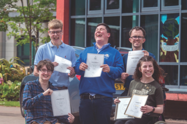 A group of DofE students smile and laugh with their certificates