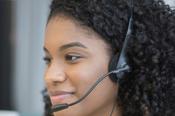 A black woman wearing a telephone headset