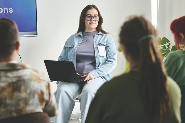 A lady with a laptop talking to a group