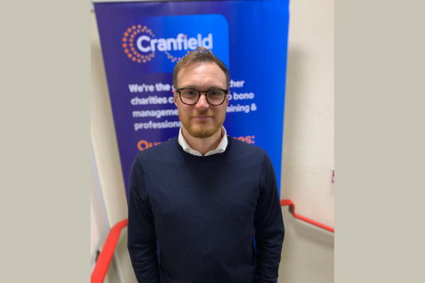 Photo of Dan Francis CEO, a man wearing glasses and navy jumper and smiling at the camera
