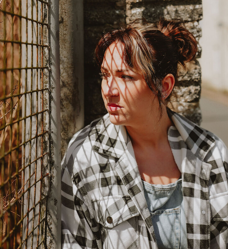 A young girls sits looking out of a caged window
