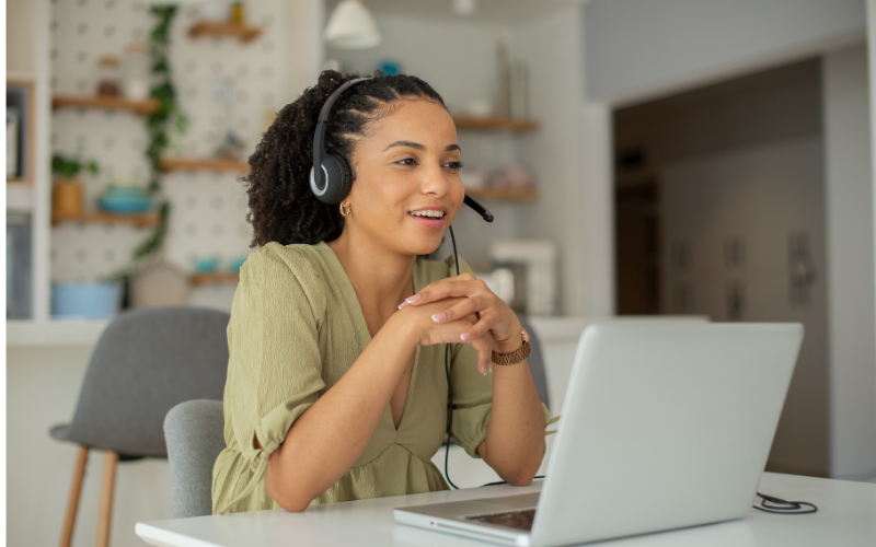 Photo of a young lady wearing headphones and looking at a computer screen