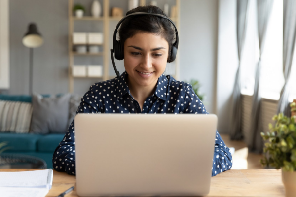 Smiling lady on laptop Cranfield Trust free charity webinar