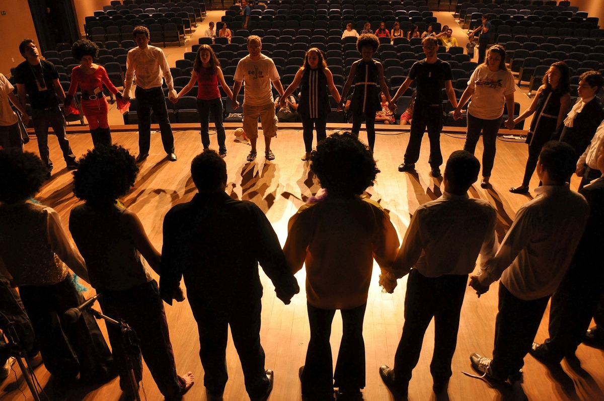 A stage with people rehearsing on it.