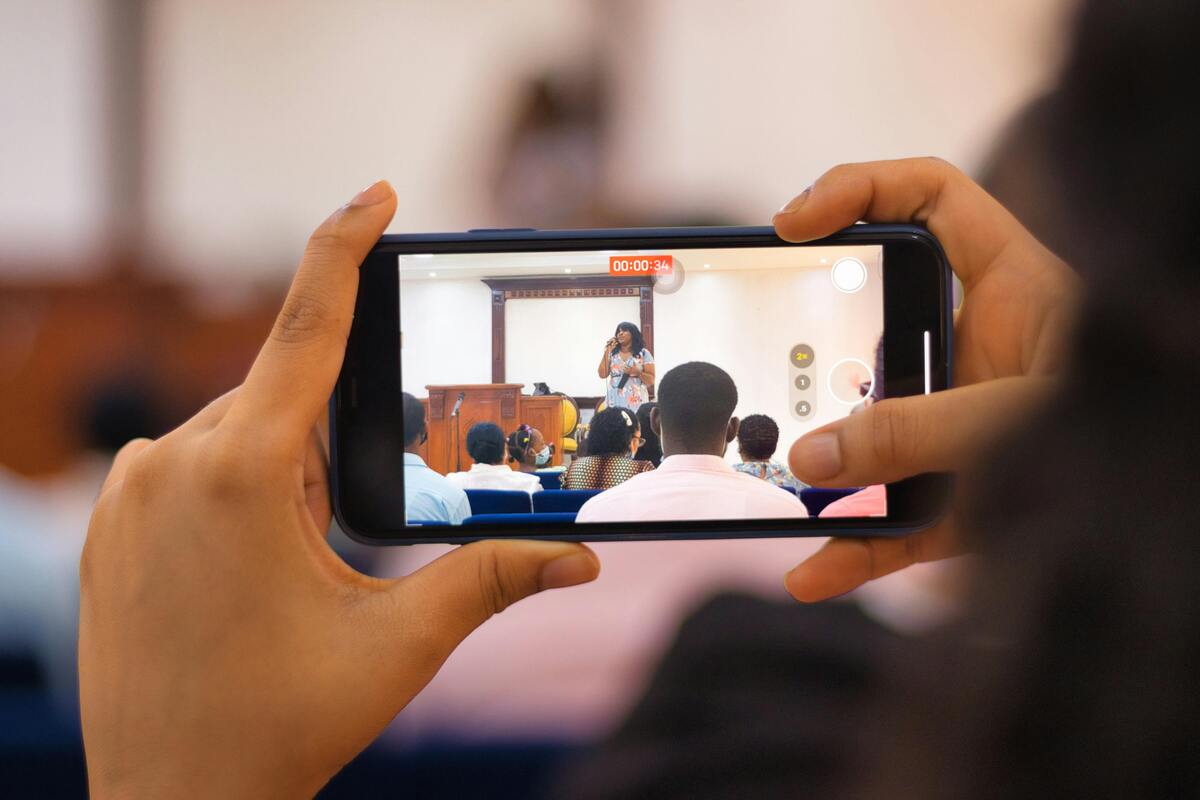 Someone with a camera phone filming a woman talking on screen