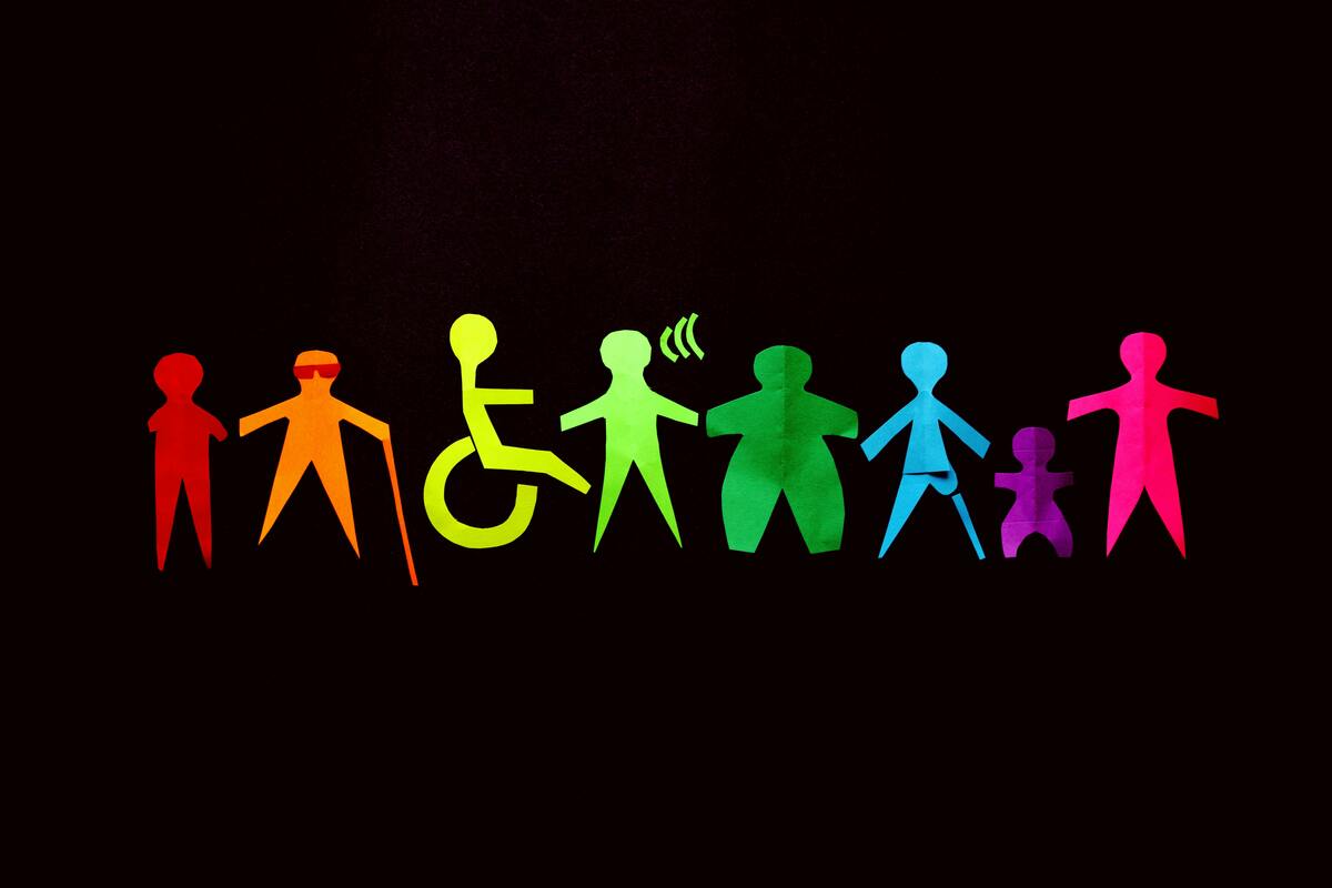 A black background with rainbow human paper cut outs with different disabilities