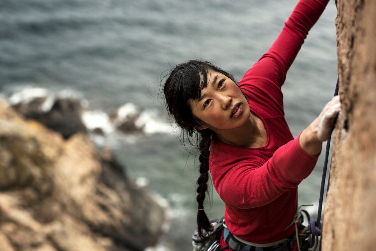 A woman climbing a steep rock face