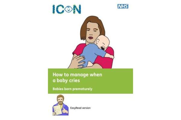 The image shows someone in a red top holding a crying baby across their chest.