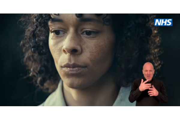 Face of a woman feeling low, with the NHS logo and a BSL interpreter on the side.