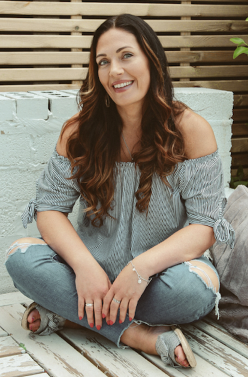 a photo of Natalie sitting cross legged and smiling 