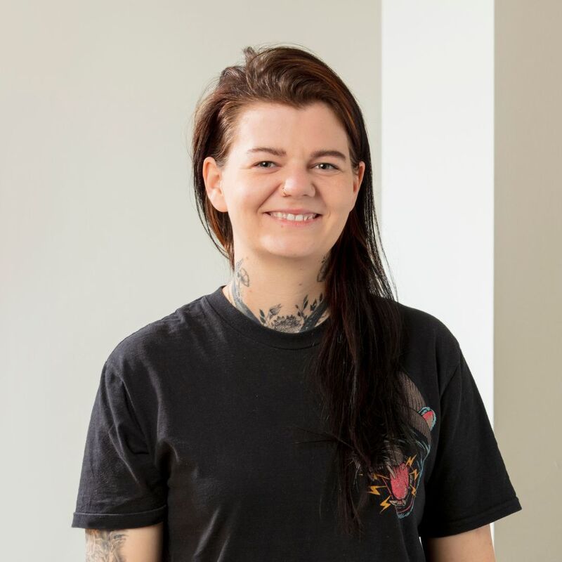 Stacey smiling at the camera wearing a black t-shirt