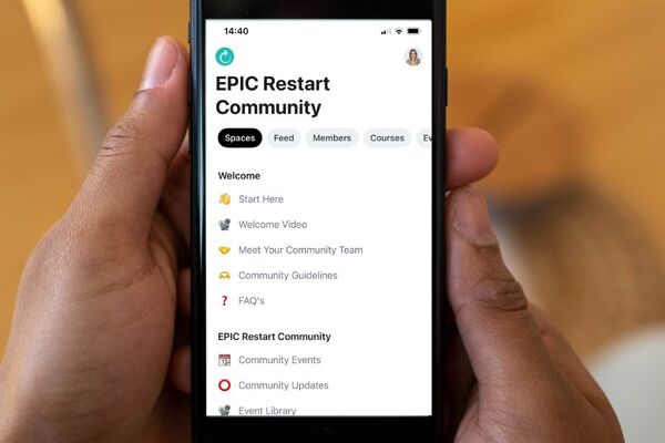 hands holding a smart phone showing the EPIC Restart Community App