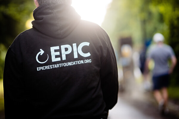 person walking away from the camera wearing an EPIC Restart black hoodie