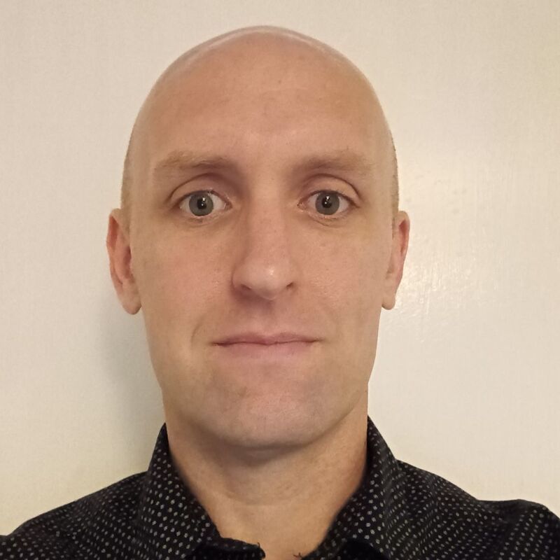 Andrew wearing a navy shirt