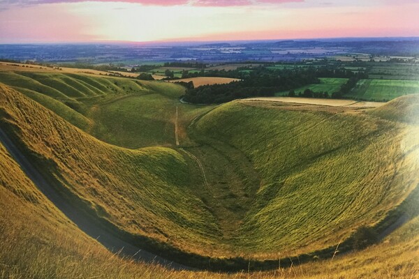 View of the Manger at Uffington - a steep sided geological feature with views beyond 