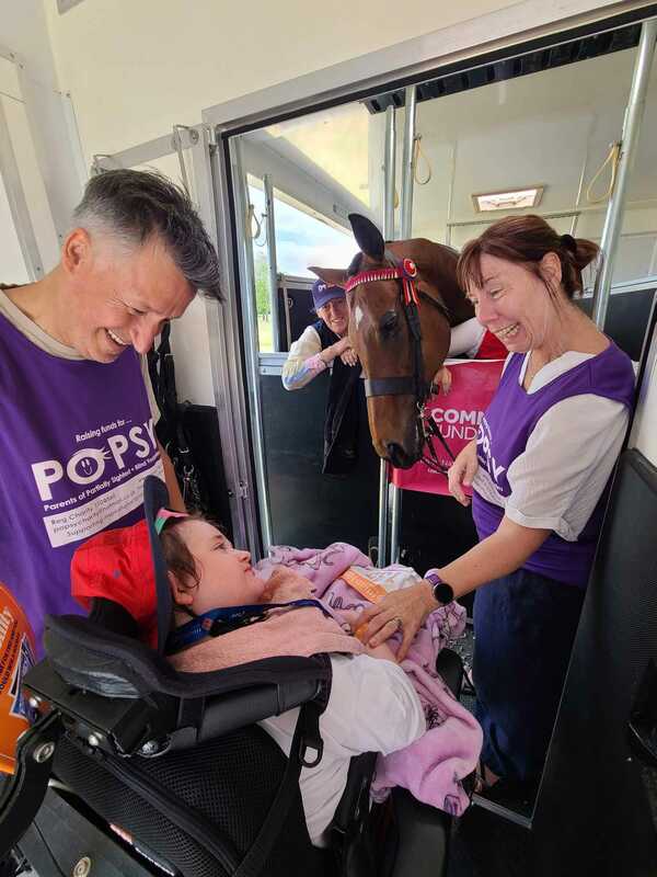 Family meeting a horse inside the Happiness Horsebox