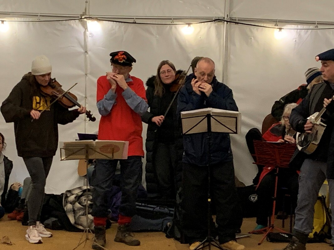 Roy Green and Jim Davies Playing Harmonica alongside other musicians at the Wassail 