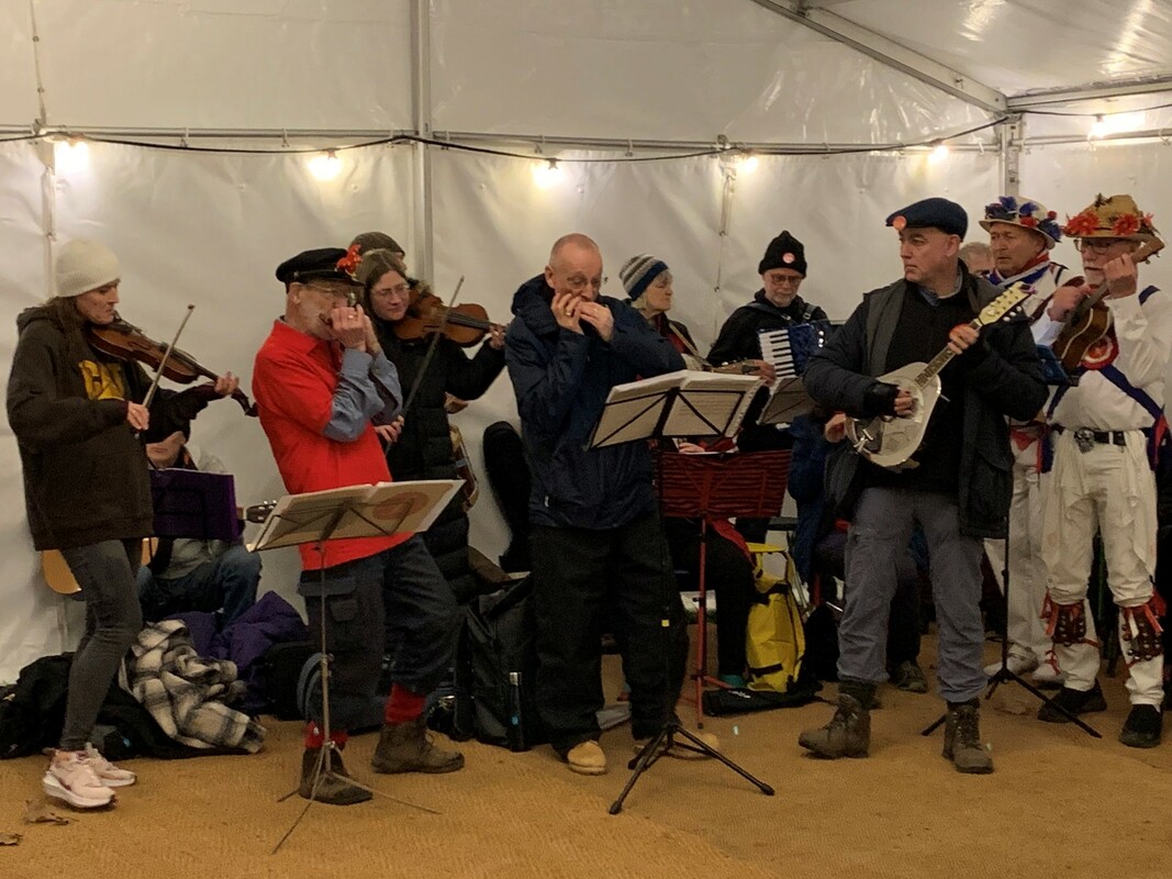 Members Roy Green and Jim Davies Playing harmonica alongside other musicians at the Wassail