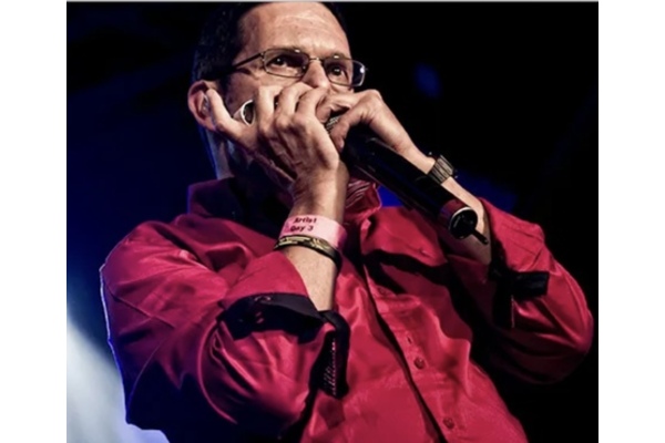 Adam Glasser in red shirt playing Harmonica