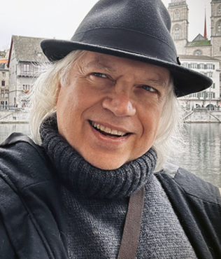 Image: Gene, smiling, wearing fedora hat