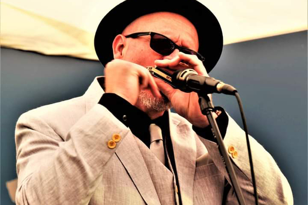 Mat Walklate playing and  looking uber cool, wearing sunglasses, a hat, and a light coloured suit