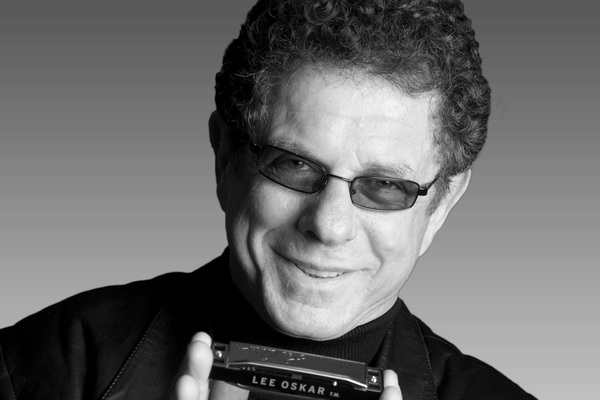 Lee Oskar holding a Lee Oskar Harmonica 