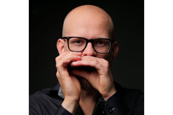 Joel playing a diatonic harmonica