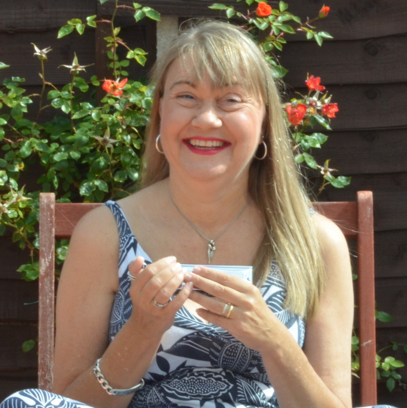 Suzy holding a harmonica outside in the sun