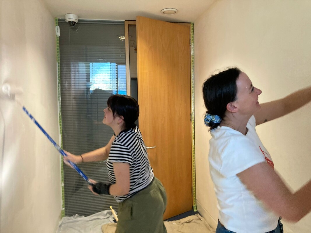 Two people painting walls