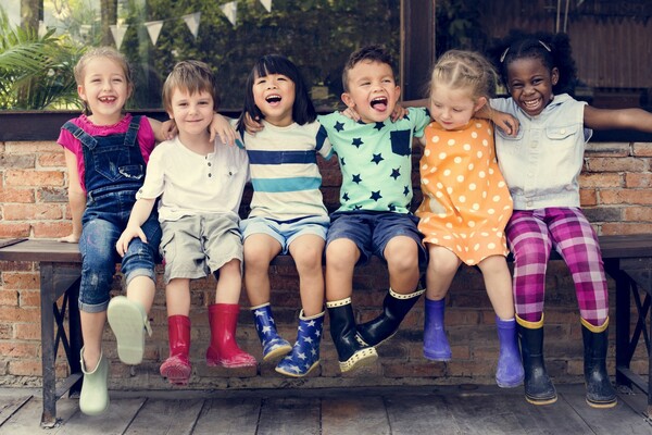 A culturally diverse group of children smile into the camera.