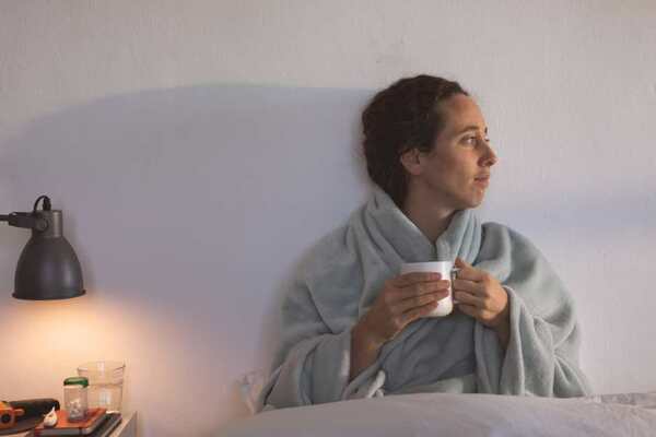 Sleeping well - woman enjoying a peaceful hot drink at bedtime