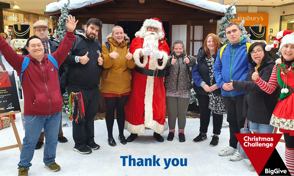 Members of the LinkAble community standing with Father Christmas and an Elf. They are all giving a 'thumbs up' 