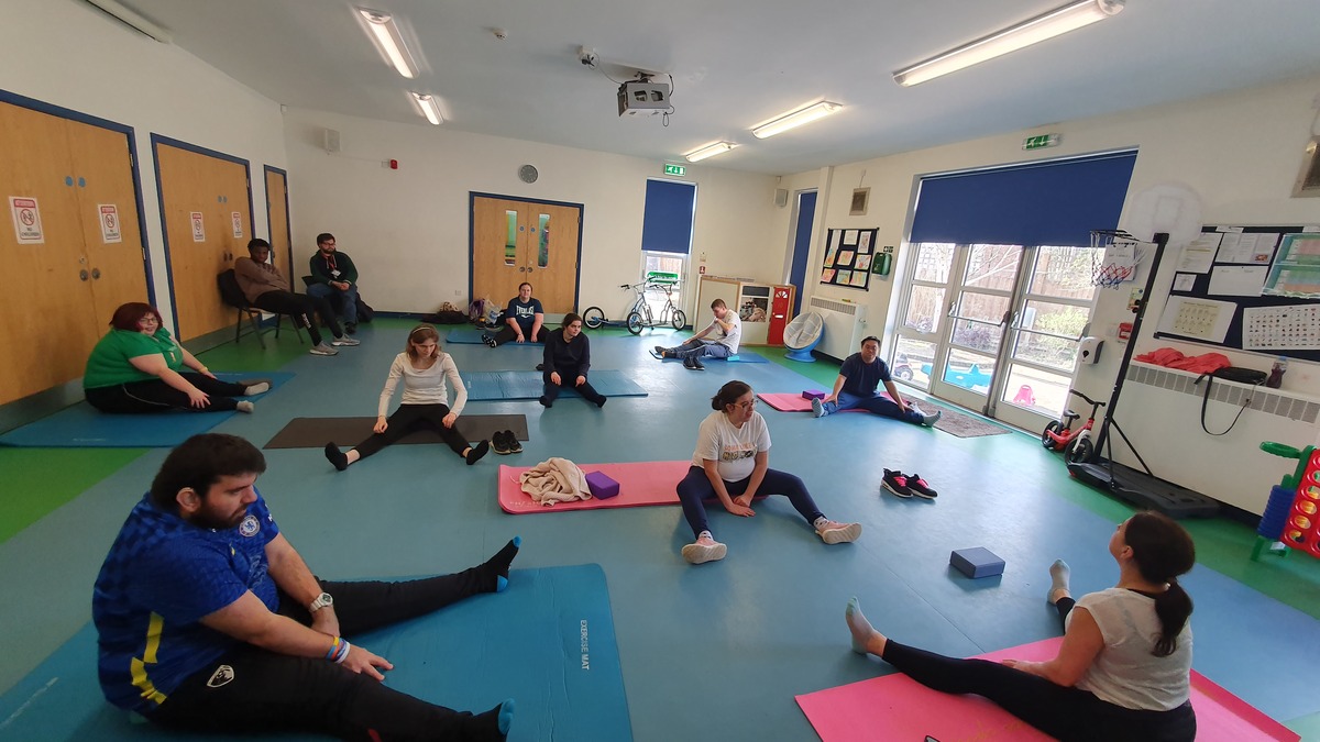 A group of people in a dance class following instructions from the dance tutor